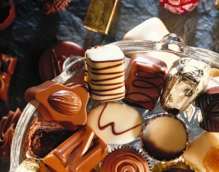 HD desktop wallpaper showing an assortment of beautifully crafted chocolate pieces in various shapes and decorations.