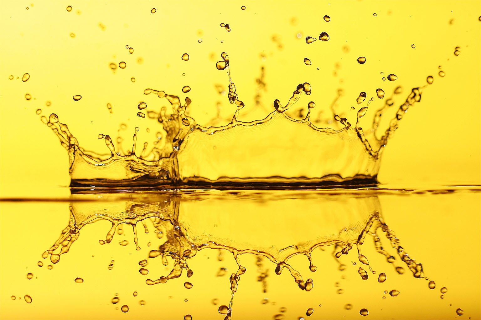A vibrant HD wallpaper showcasing an artistic splash of water against a golden background, highlighting elemental beauty and fluid motion.