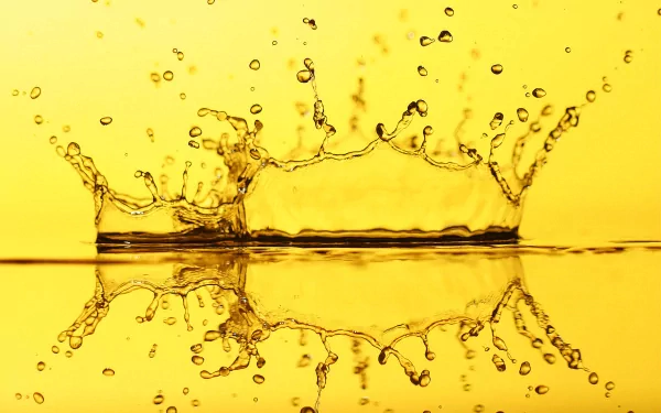 A vibrant HD wallpaper showcasing an artistic splash of water against a golden background, highlighting elemental beauty and fluid motion.