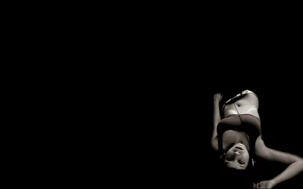 A black and white HD desktop wallpaper features a woman wearing headphones, immersed in music, capturing a moment of relaxation and enjoyment in a minimalistic setting.