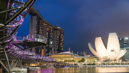 Night view of Singapore’s Helix Bridge and Marina Bay Sands with illuminated buildings reflected in the water, captured in an HD desktop wallpaper.