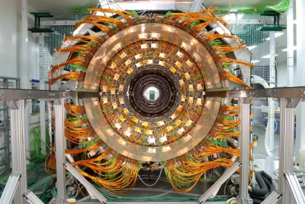 HD desktop wallpaper showcasing the intricate, man-made Large Hadron Collider with detailed wiring and circular metallic structure in a high-tech facility.