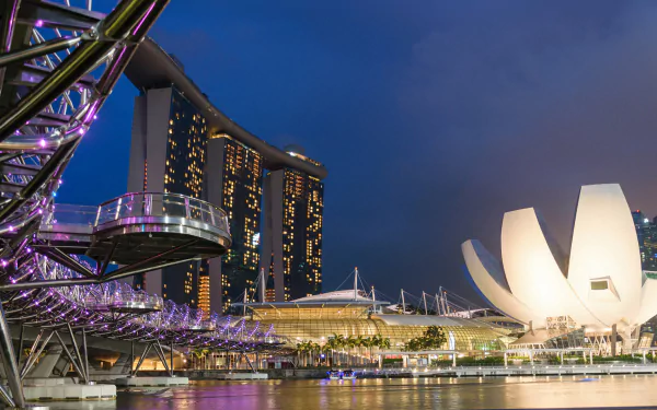 Night view of Singapore’s Helix Bridge and Marina Bay Sands with illuminated buildings reflected in the water, captured in an HD desktop wallpaper.
