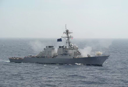 USS John S. McCain (DDG-56), an Arleigh Burke–class missile destroyer of the United States Navy, steaming at sea with crew on deck and its Mk-45 naval gun visible.