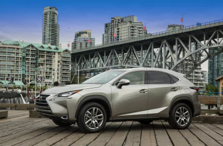 Silver Lexus NX 200t parked on a waterfront pier with a steel bridge and downtown cityscape behind — HD PC desktop wallpaper of a Lexus vehicle.