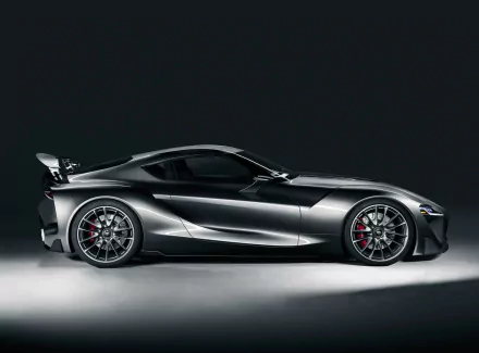 Sleek silver Toyota FT-1 concept supercar showcased in a high-definition desktop wallpaper, highlighting its futuristic design and sculpted lines against a dark background.