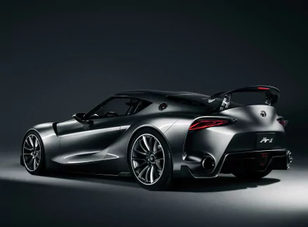A sleek silver Toyota FT-1 concept supercar, showcasing its aerodynamic design and aggressive stance against a dark background, serves as an impressive HD desktop wallpaper.