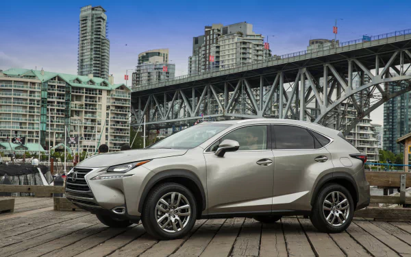 Silver Lexus NX 200t parked on a waterfront pier with a steel bridge and downtown cityscape behind — HD PC desktop wallpaper of a Lexus vehicle.