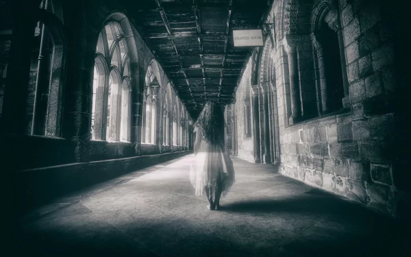 HD wallpaper featuring a dark, eerie hallway with a ghostly figure in a flowing dress walking away. The atmosphere is haunting and mysterious, enhancing its use as a desktop background.