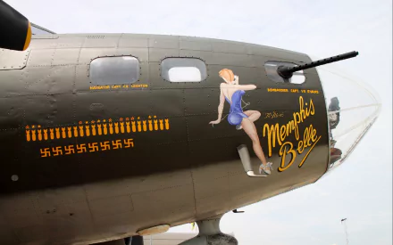 HD desktop wallpaper featuring military aircraft nose art of a pin-up girl and Memphis Belle text on the side of a vintage bomber plane.