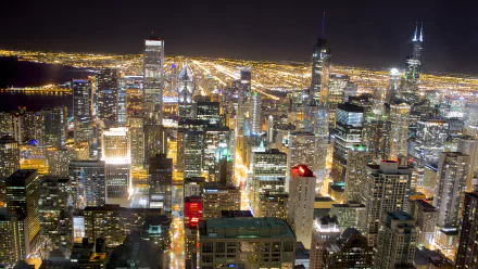 4K Ultra HD desktop wallpaper showcasing a vibrant nighttime cityscape of Chicago with illuminated skyscrapers and streets extending into the horizon.