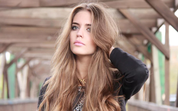 HD PC wallpaper featuring Spanish model Clara Alonso with long hair posing thoughtfully on a wooden bridge background.