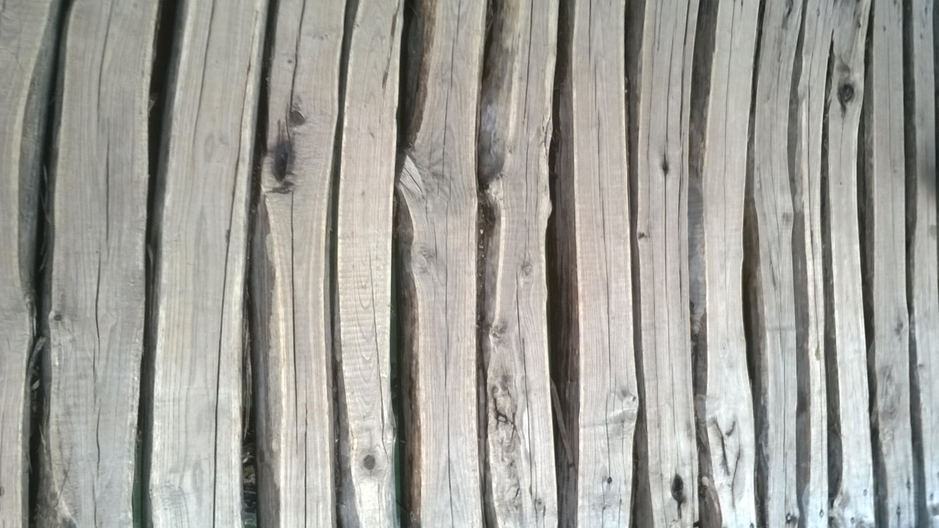 HD desktop wallpaper featuring a close-up woodcut pattern of aligned logs forming a textured wooden walkway.