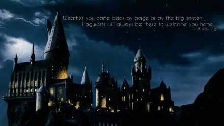 HD desktop wallpaper featuring Hogwarts Castle from the Harry Potter movies. The nighttime image includes a quote from J.K. Rowling: Whether you come back by page or by the big screen, Hogwarts will always be there to welcome you home.