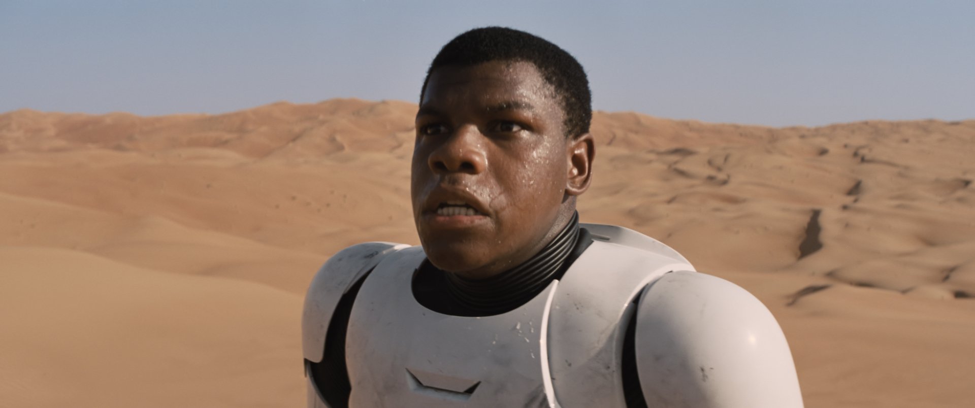 HD desktop wallpaper featuring John Boyega as Finn from Star Wars Episode VII: The Force Awakens in desert terrain wearing stormtrooper armor.