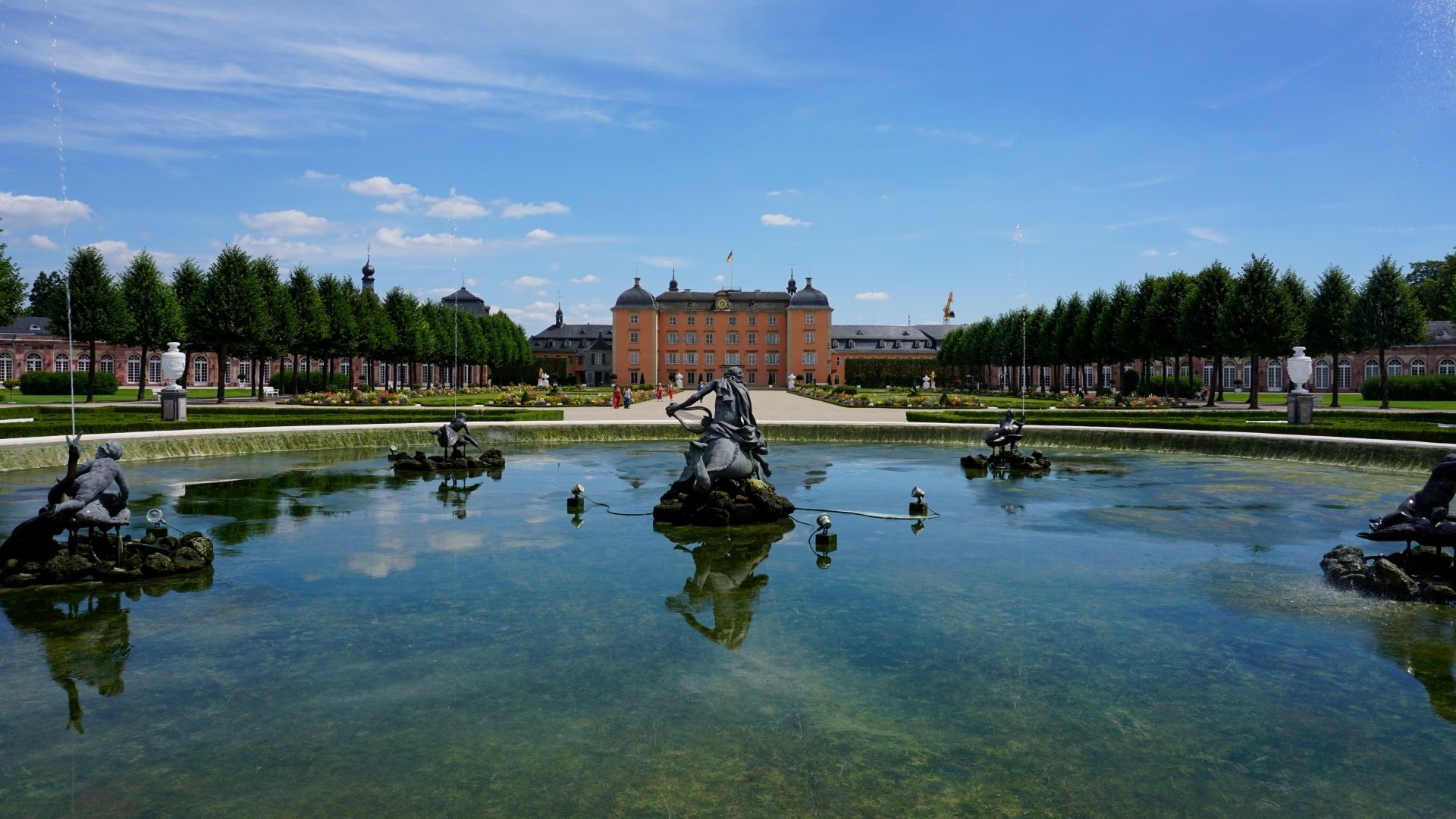 HD PC desktop wallpaper and background: Schwetzingen Palace, man-made formal gardens with statues and a central reflecting pond beneath a bright blue sky.