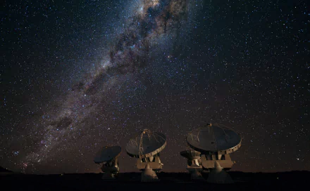 A 4K Ultra HD image of a man-made radiotelescope array under a starry night sky with the Milky Way visible above.