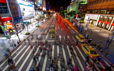 A vibrant night scene of a busy Taipei street with light trails from vehicles, captured in 4K Ultra HD as a striking man-made urban landscape.