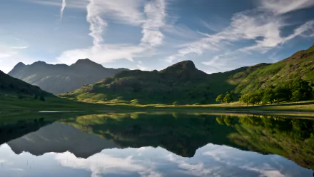 A serene 4K Ultra HD nature landscape showing mountains and clouds reflected in a calm lake, designed as a PC desktop wallpaper and background.