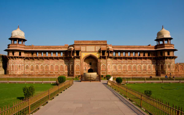 A stunning HD wallpaper of Agra Fort, showcasing its intricate architecture and expansive grounds under a clear blue sky. A striking representation of man-made beauty.