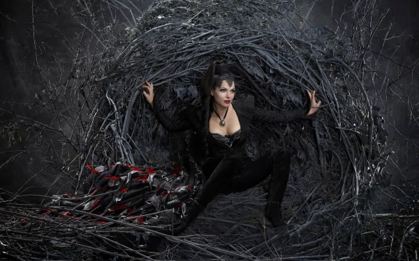 Lana Parrilla as the Evil Queen, Regina Mills, from Once Upon A Time, poses dramatically in a dark, twisted environment, embodying her fierce character in this HD wallpaper.