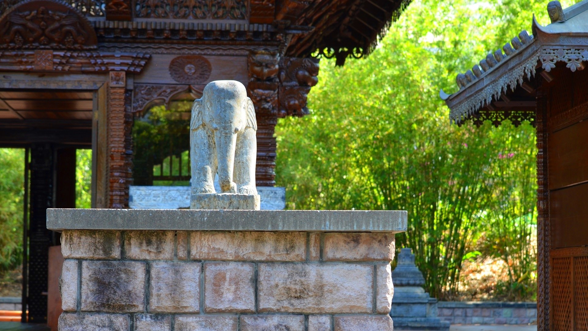 HD PC desktop wallpaper/background: man-made stone elephant statue at a Nepalese pagoda in Brisbane, Australia, carved wooden roofs and sunlit green foliage.