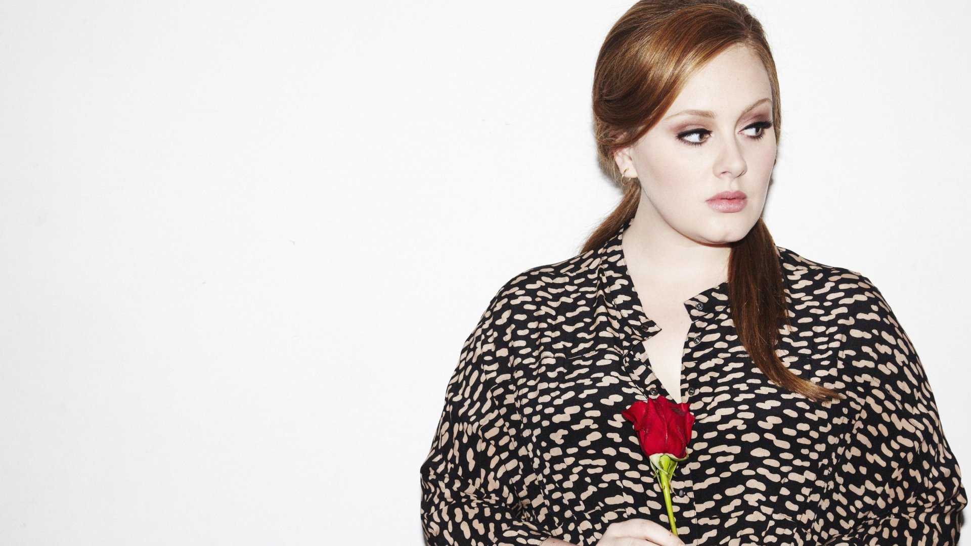 HD desktop wallpaper of British singer Adele holding a red rose against a plain white background, showcasing her music persona.