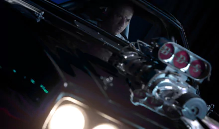 Vin Diesel as Dominic Toretto in a high-octane scene from Furious 7, captured in an HD desktop wallpaper showcasing intense focus and powerful muscle car details.