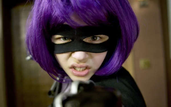 Close-up of Hit-Girl from the movie Kick-Ass, portrayed by Chloë Grace Moretz, with purple hair and a black mask, captured in 4K Ultra HD for a PC desktop wallpaper.