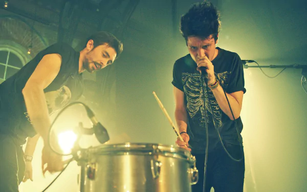 HD desktop wallpaper featuring Bastille, the English rock band, performing live with energetic stage presence and vibrant lighting.
