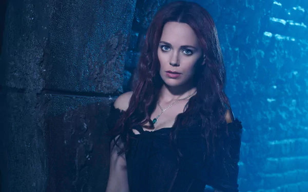 Brunette actress Katia Winter poses against a dark textured wall in this 4K Ultra HD PC desktop wallpaper and background.