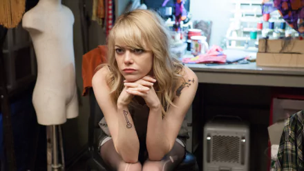 Pensive young woman seated in a cluttered dressing room; 2K Quad HD PC desktop wallpaper inspired by the movie Birdman.