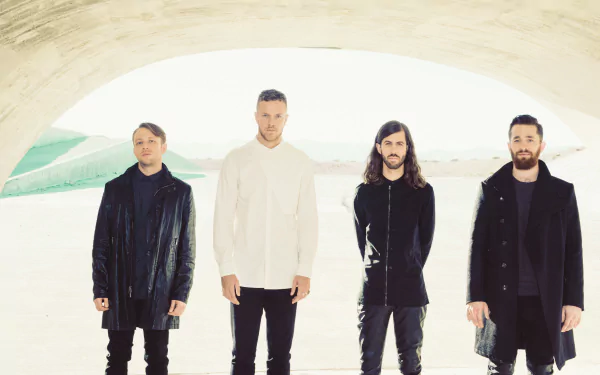 Image of the American alternative band Imagine Dragons, featuring the four members standing together in a modern architectural setting. 4K Ultra HD wallpaper for music fans.