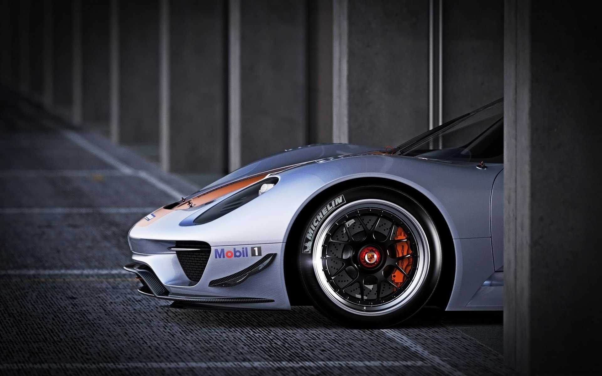 Close-up of a Porsche 918 Spyder vehicle front wheel and nose in a dim parking garage — orange brake caliper and alloy rim, HD PC desktop wallpaper background.