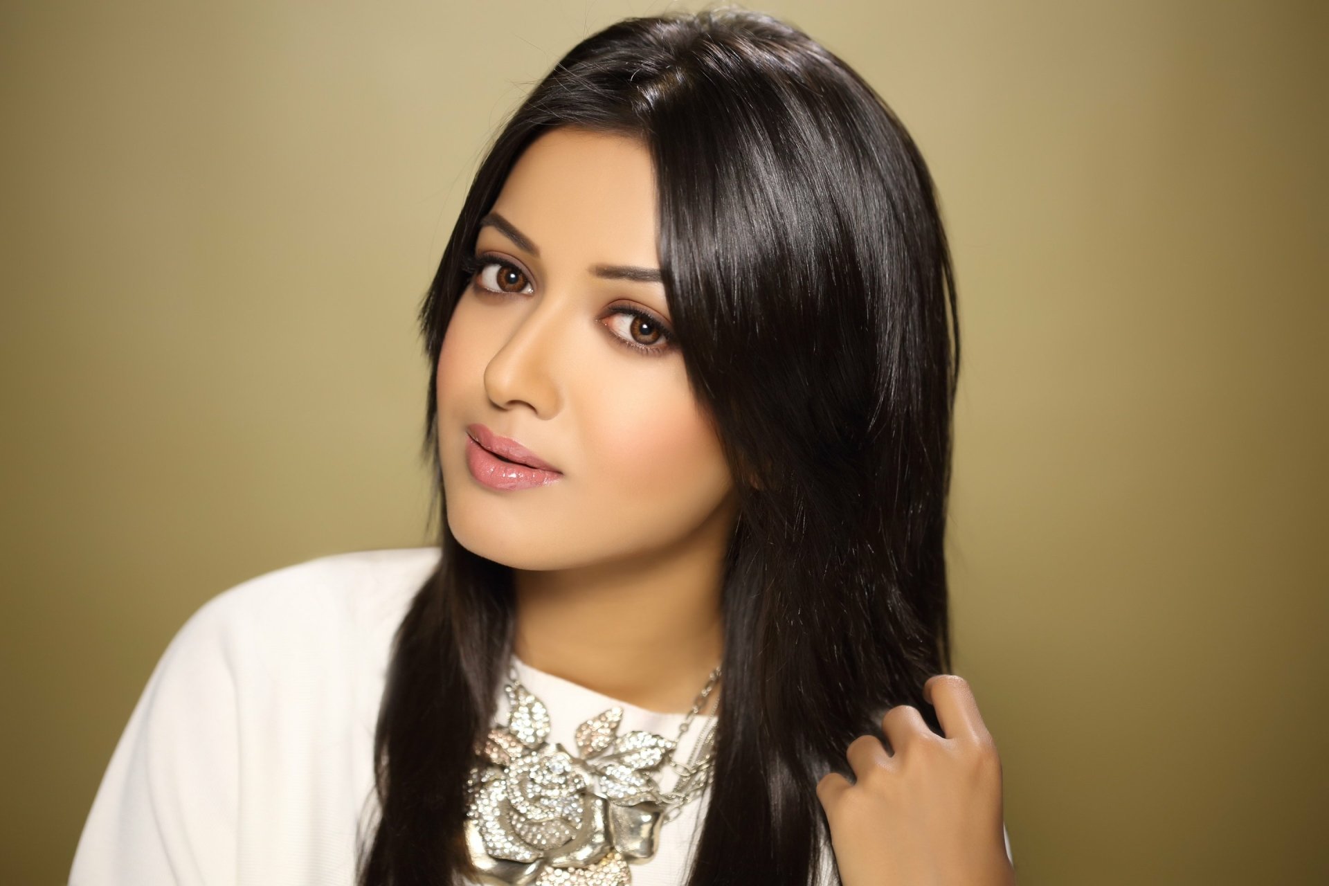 A stunning HD wallpaper featuring Bollywood actress Catherine Tresa, showcasing her elegance with long, dark hair and a stylish necklace against a soft, warm background.