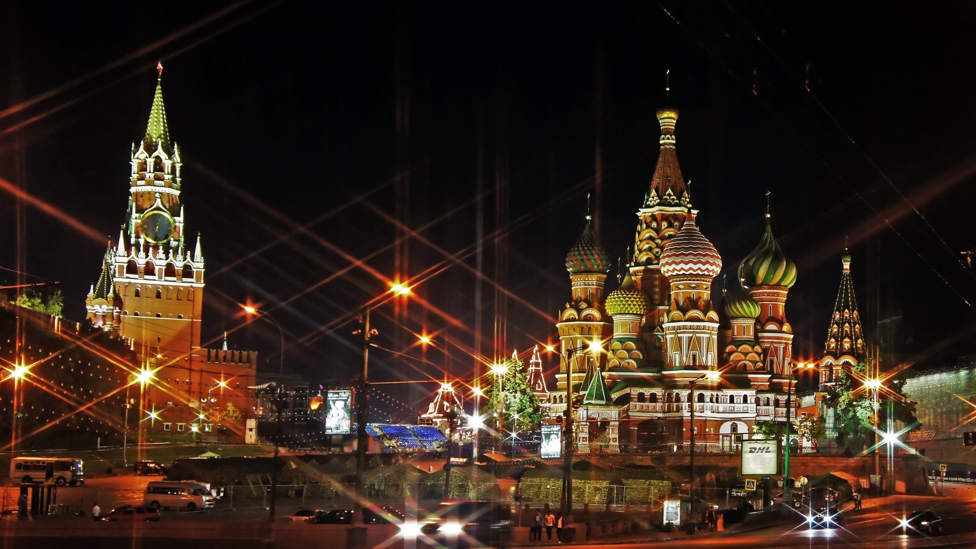 4K Ultra HD PC desktop wallpaper: Saint Basil's Cathedral in Moscow at night, illuminated onion domes and Kremlin tower with starburst lights — religious landmark in Red Square.