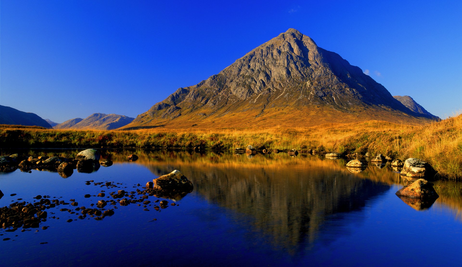 HD PC desktop wallpaper and background: vivid nature landscape of a solitary mountain mirrored in a glassy blue lake beneath a clear, deep-blue sky.