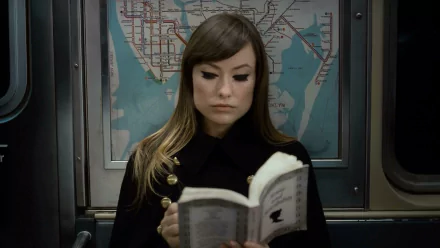 HD desktop wallpaper: an actress from the movie The Longest Week reads a book on a subway car, a transit map visible on the wall behind her.