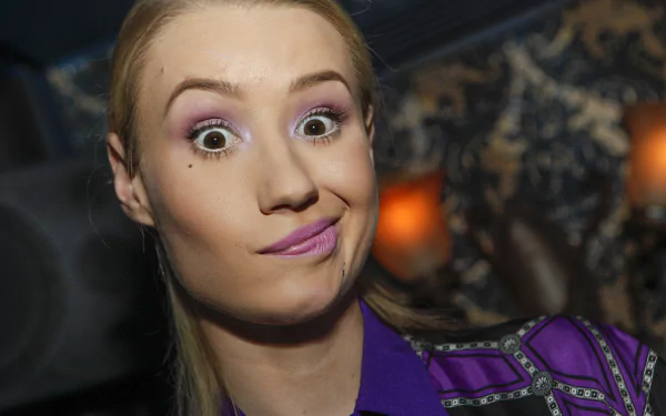 HD wallpaper of an Australian singer with blonde hair, brown eyes, and lipstick, making a playful expression.