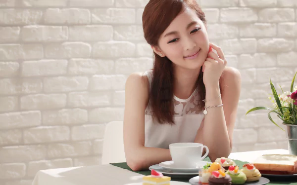 A smiling Asian woman enjoys a colorful meal at a table, surrounded by desserts, in a bright, inviting setting. Perfecting a joyful moment in Taiwanese cuisine.