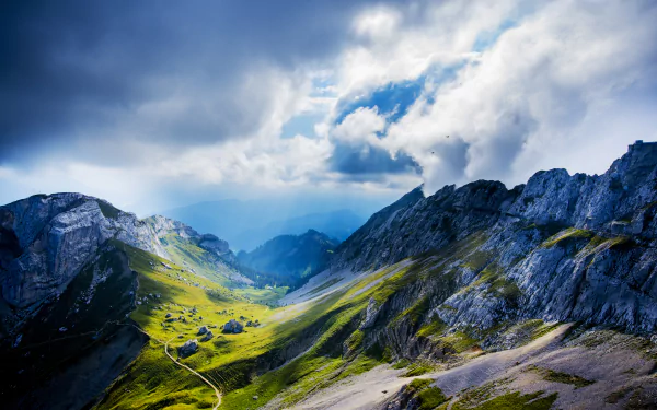 Stunning 4K Ultra HD landscape of Mount Pilatus in Lucerne, Switzerland, showcasing rugged mountains and lush green valleys under a dramatic cloudy sky.