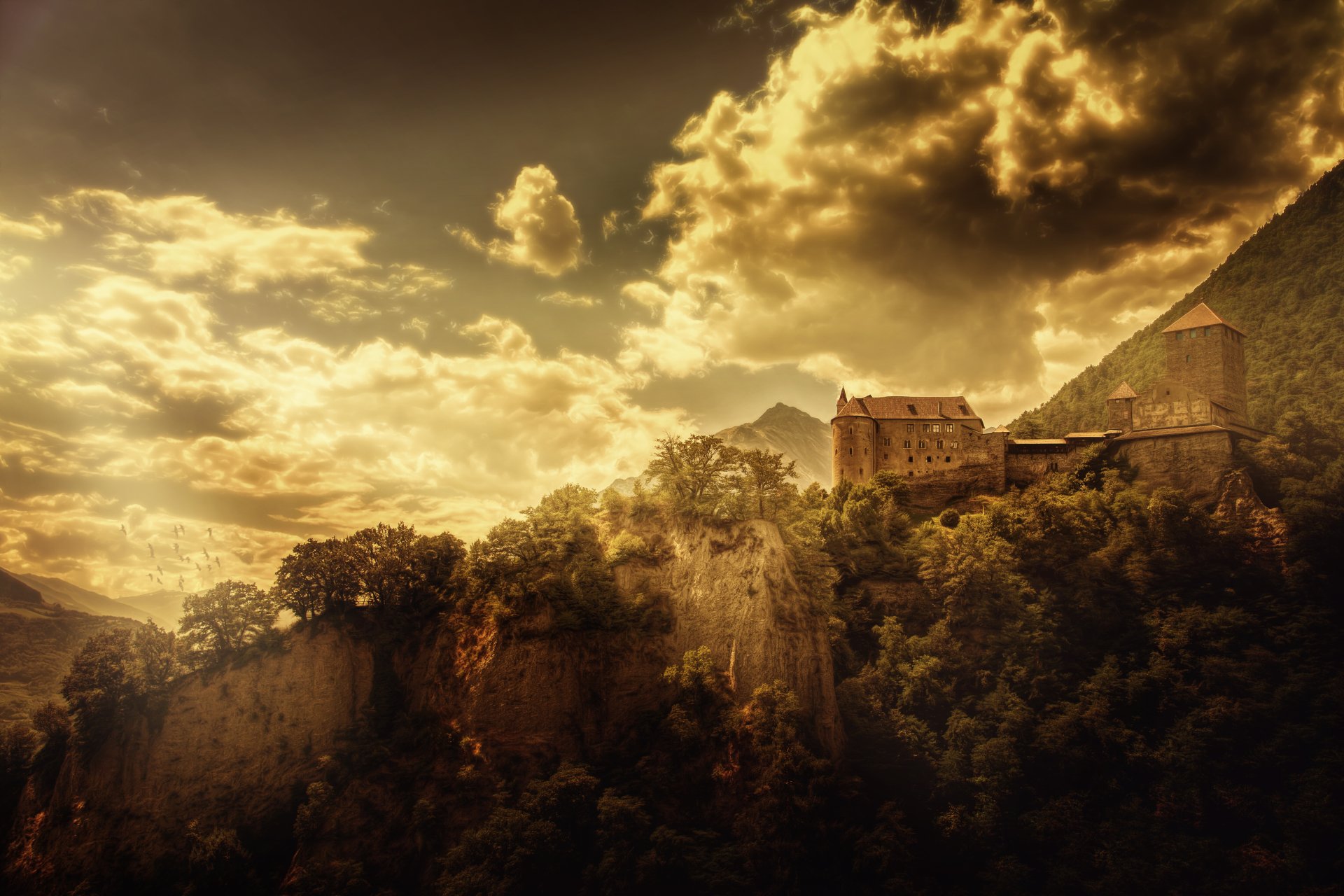 A dramatic 4K Ultra HD landscape of Tirol Castle perched on a mountain in Austria, with golden clouds and sky casting light over the lush terrain.