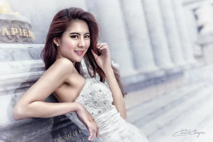 A Thai woman in an elegant dress smiles by an ornate monument, showcasing the beauty of Asian culture in a serene, HD background setting.