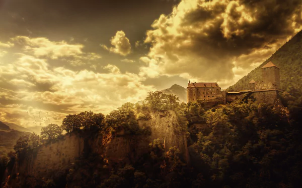 A dramatic 4K Ultra HD landscape of Tirol Castle perched on a mountain in Austria, with golden clouds and sky casting light over the lush terrain.