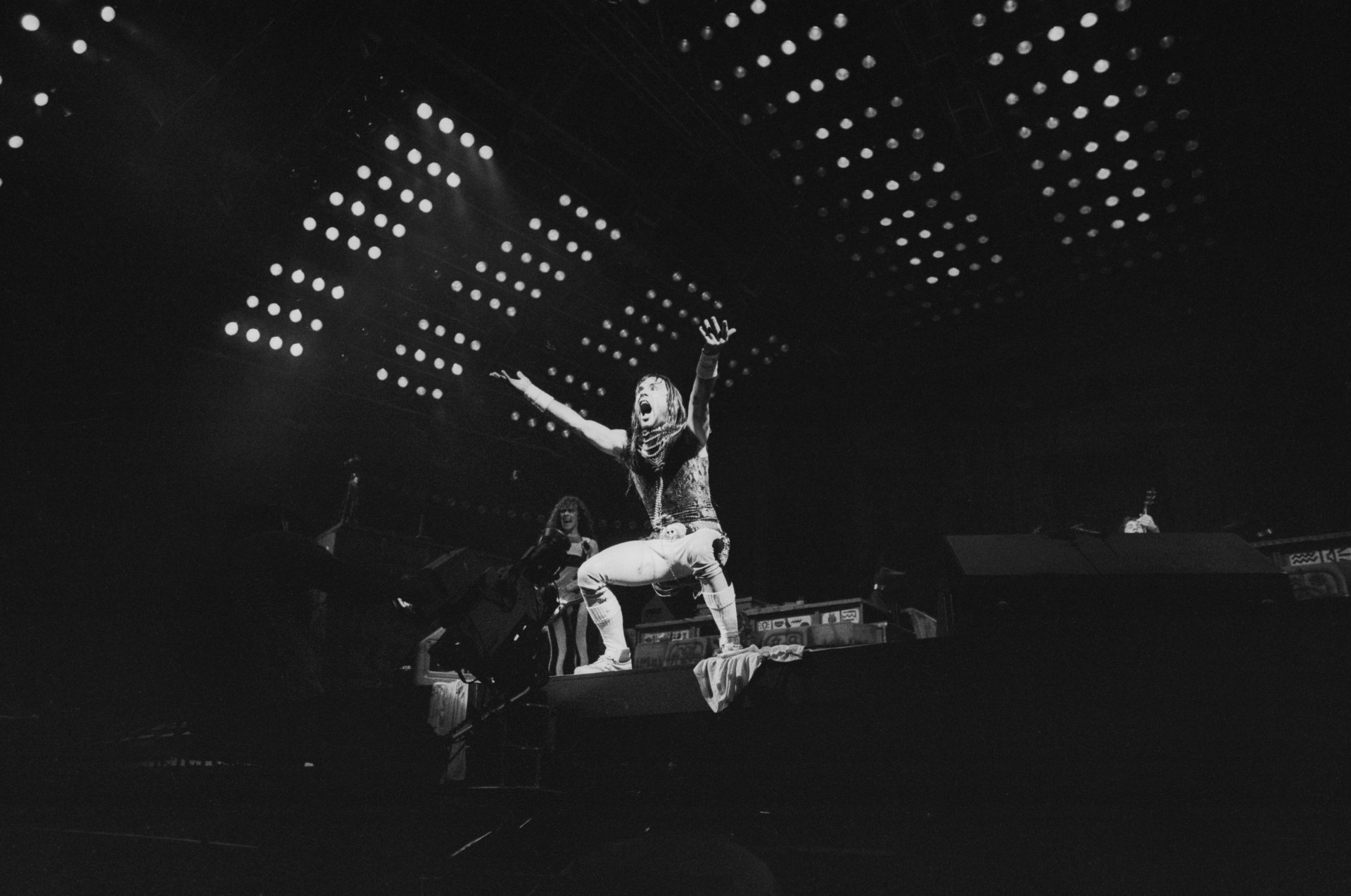 Black-and-white 4K Ultra HD desktop wallpaper featuring Iron Maiden performing live on stage under bright spotlights.