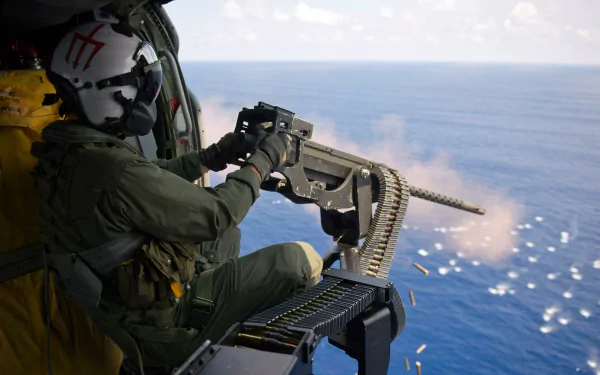A soldier operating a machine gun from a helicopter, overlooking the ocean. This high-definition image serves as a striking desktop wallpaper and background.