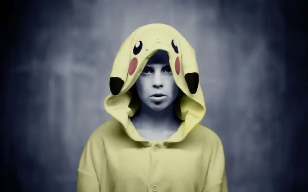 Yolandi Visser wearing a Pikachu-themed cosplay hoodie, featured in an HD PC desktop wallpaper with a dark, blurred background.