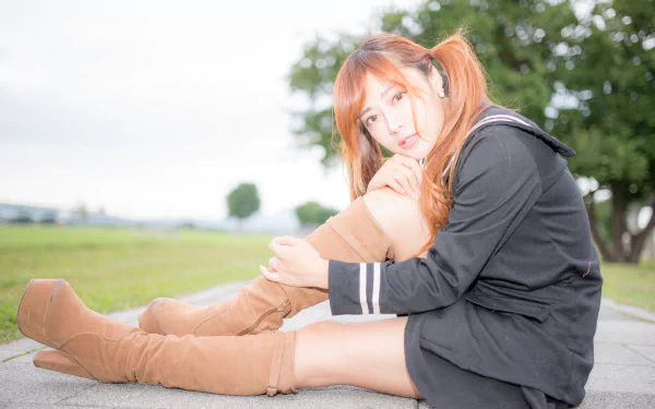 A Taiwanese woman, Xiao Xi, poses in stylish brown boots against a soft bokeh background, capturing a serene moment in nature. HD wallpaper for a chic aesthetic.