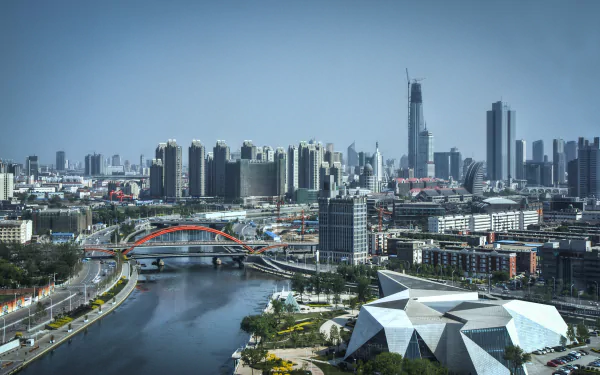 HD desktop wallpaper showing the modern cityscape of Tianjin, China, featuring a river, bridges, and high-rise buildings under a clear sky.