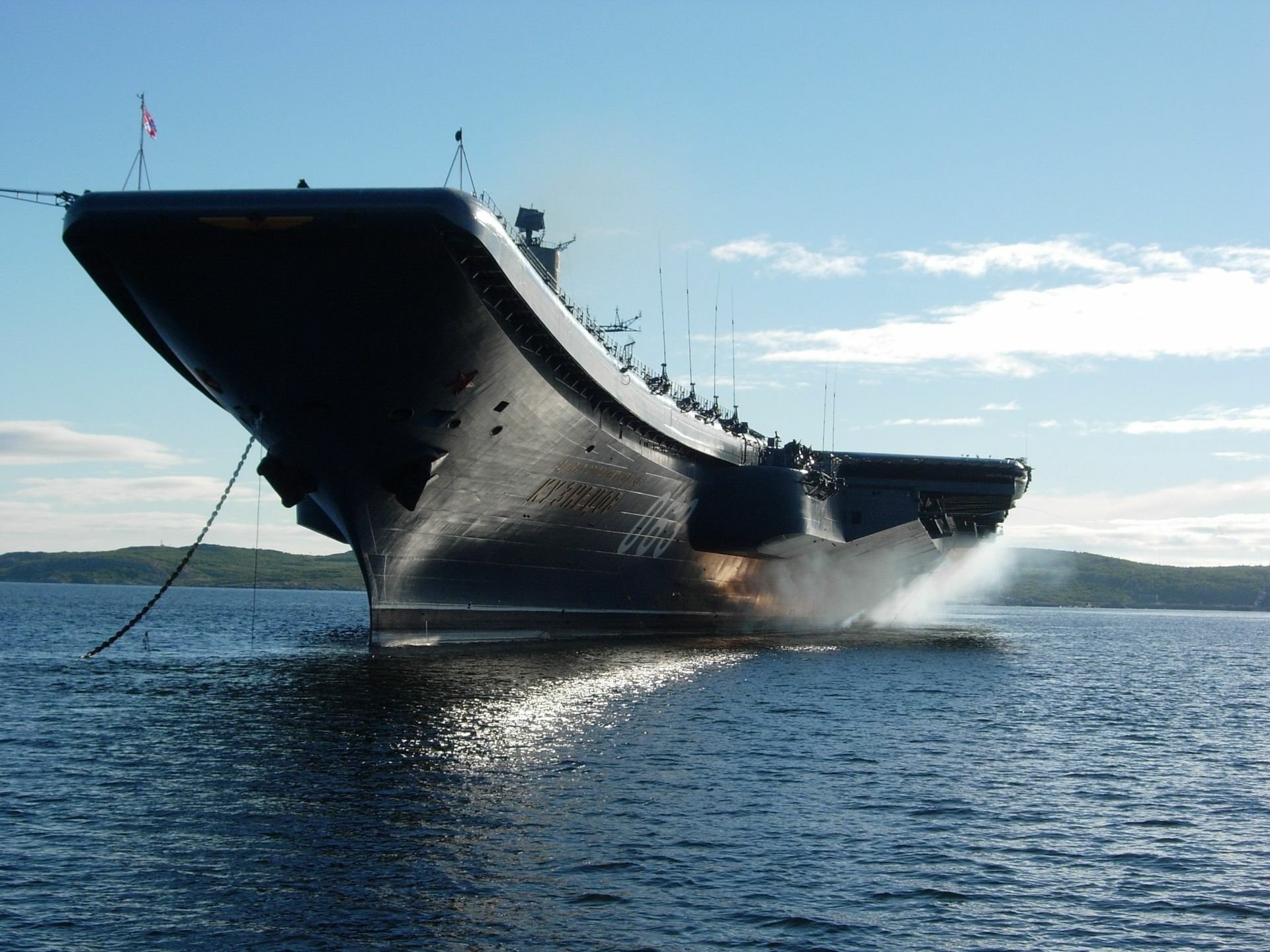 HD desktop wallpaper featuring the Russian aircraft carrier Admiral Kuznetsov, a powerful military warship, cruising through calm waters under a clear sky.